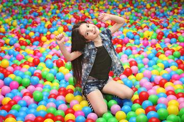 Fototapeta na wymiar Cute girl playing with plastic balls