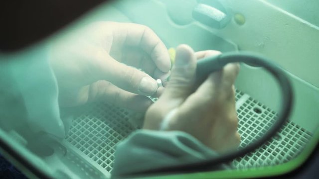 Close up of a dental technician of grinding a ceramic crown in dental lab 4K
