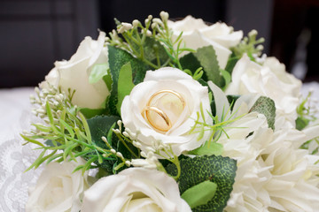 Wedding rings gold on flower bouquet close up