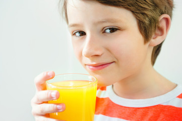 Smiling boy enjoying with glass of yellow juice