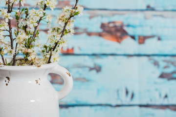 White vintage vase with bradford pear blossoms