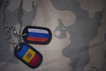 army blank, dog tag with flag of russia and moldova on the khaki texture background. military...
