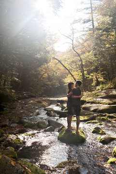 Young couple embracing in a mossy stream