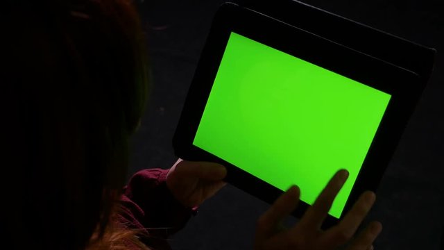 Student holding a tablet pc with green screen