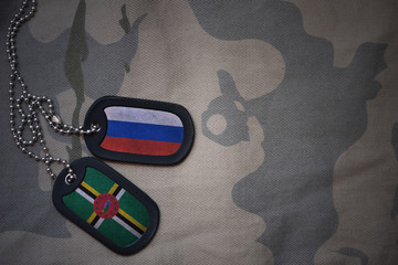 army blank, dog tag with flag of russia and dominica on the khaki texture background. military...