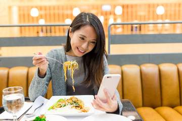 Woman use of mobile phone and eating together