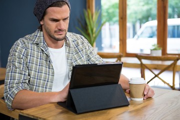 Man using digital table while having coffee in cafe