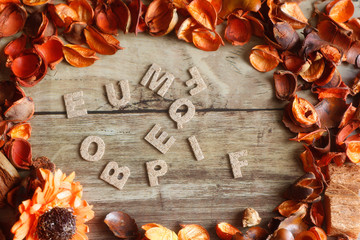 orange petals and dried flowers and alphabet on old wooden plates.