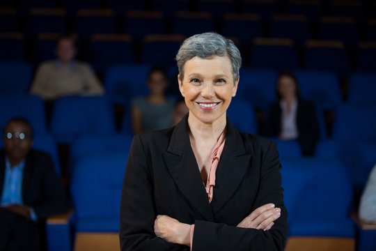 Female business executive with arms crossed at conference center