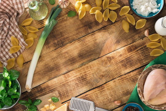 Frame of ingredients for cooking Italian pasta on wooden table