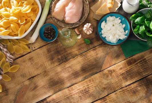 Ingredients for cooking Italian pasta on wooden table with border