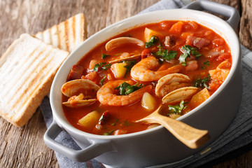 Manhattan tomato clam chowder soup close-up in a saucepan. horizontal 