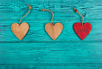 Wooden hearts on a blue background. Pendants made of wood in the form of heart. Copy space. Top view