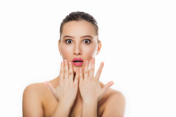 beautiful brunette girl with collected hair with a gentle makeup looks surprised, eyes wide open into the chamber of the hand near the lips the emotions of white background isolate