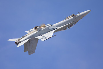Fototapeta na wymiar F-18 Hornet in a roll at takeoff, against the blue sky