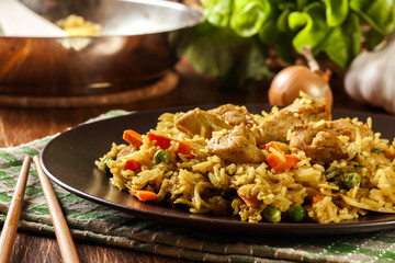 Fried rice nasi goreng with chicken and vegetables on a plate