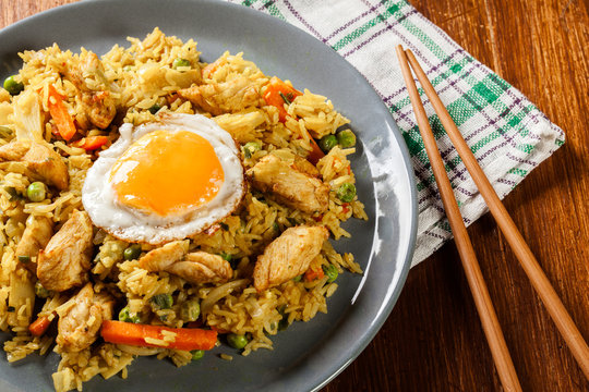 Fried rice nasi goreng with chicken egg and vegetables on a plat