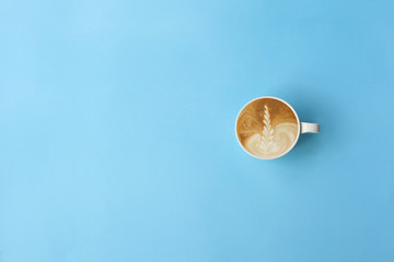 Cup of coffee latte art on the light blue background. Top view, copy space.