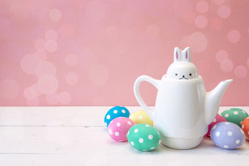 Kettle-hare with Easter eggs on a pink background.