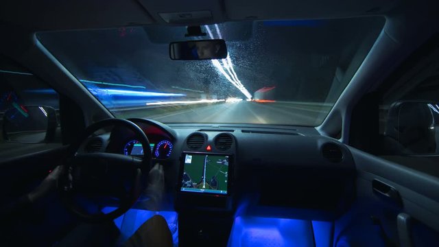The man drive a car in the night city. Inside view. Hyperlapse. Wide angle