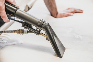 Professional cleaning of upholstery with spray extraction vacuum – deep fabric washing and stain removal service