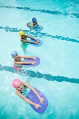 Children using kickboard while swimming in pool