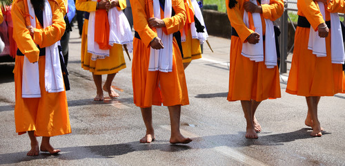 soldiers with orange clothes march through the city during a fes