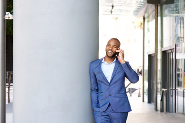 young african businessman talking on cell phone while in the city