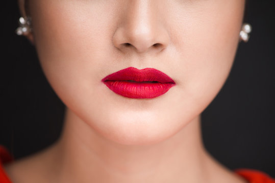 Beauty. Close up view of beautiful woman lips with red matt lipstick
