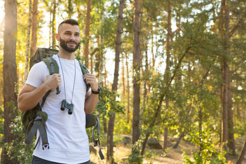 Handsome male hiker enjoying backpacking in the forest