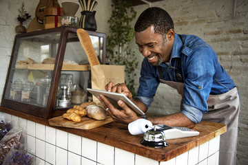 Man using devices for online business order at bakehouse