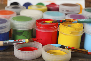 Artistic brushes and jars with bright gouache on the table in the artist's studio. Close-up....