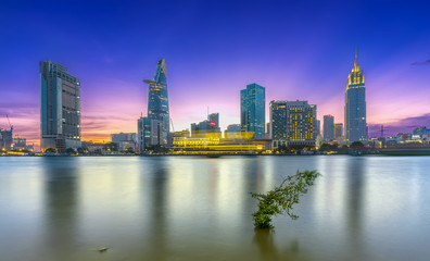Ho Chi Minh City, Vietnam - March 25th, 2017: Riverside City sunrays clouds in the sky at end of day brighter coal sparkling skyscrapers along beautiful river in Ho Chi Minh City, Vietnam