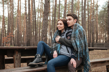 Fototapeta premium Couple looking away while sitting on bench