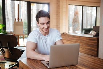smiling man using laptop