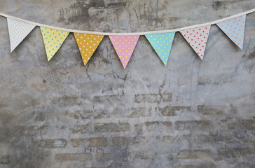 Colorful party flag over cement wall texture background