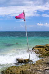 Red flag on the shore. Strong wind and dangerous condition for swimming.