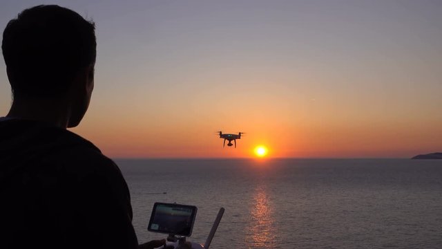 Drone flies over the sea toward the sunset