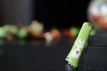 Obraz premium Green beaded bracelet with white cat and red hearts