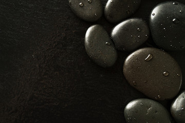 Beautiful picture of Spa Hot Stones, View from Above. Dark Background. Top. Spa Concept. Side Composition.