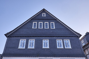 Traditional slate slab cladded house gable with white windows in Winterberg Germany