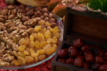 Large collection of nuts, seeds and dried fruits in brown wooden bowls isolated on a golden background