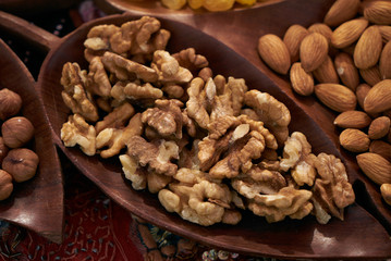 Set of different nuts, almonds, walnuts, hazelnuts  in brown wooden bowl. Close-up