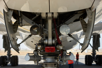 Front landing gear of big passenger aircraft closeup high detailed view. Close-up of a Airplane chassis. - obrazy, fototapety, plakaty