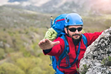 Fototapete Bergsteigen Climbers reaches the top of mountain peak, search help hand. Climbing and mountaineering sport  © Mediteraneo