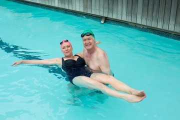 Loving mature couple enjoying in swimming pool