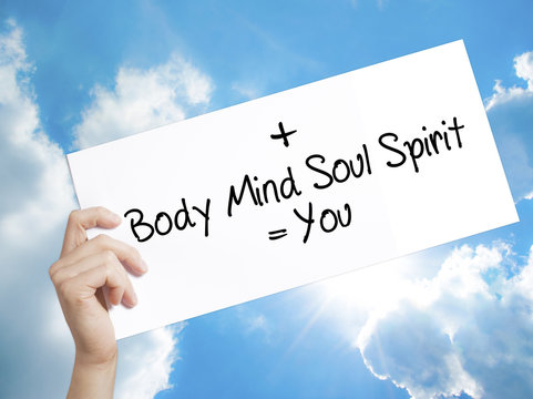 Body + Mind + Soul + Spirit = You Sign on white paper. Man Hand Holding Paper with text. Isolated on sky background