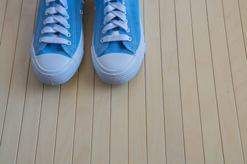 Blue new sneakers on the wooden background