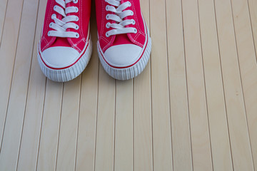Red new sneakers on the wooden background