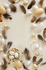Easter eggs with feather on light wooden background